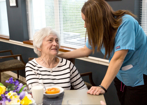 Caregiver interacting with a resident at a dining table