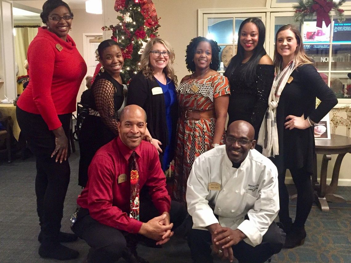 Staff members posing together in a decorated common area