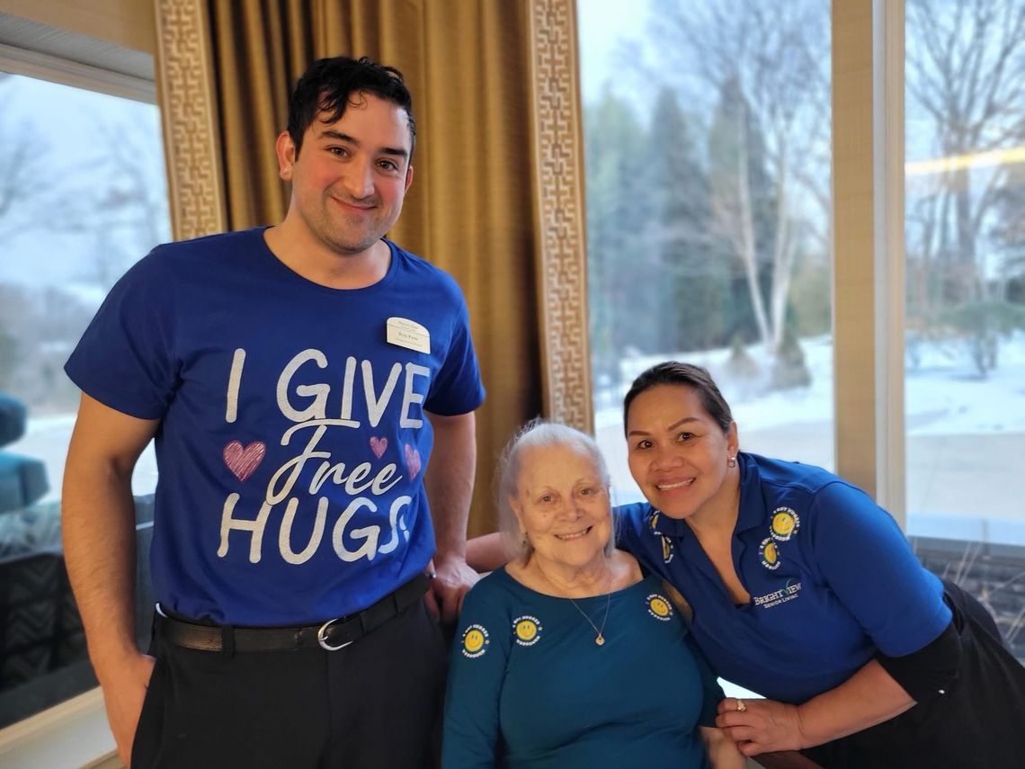 Staff members and a resident smiling in a common area