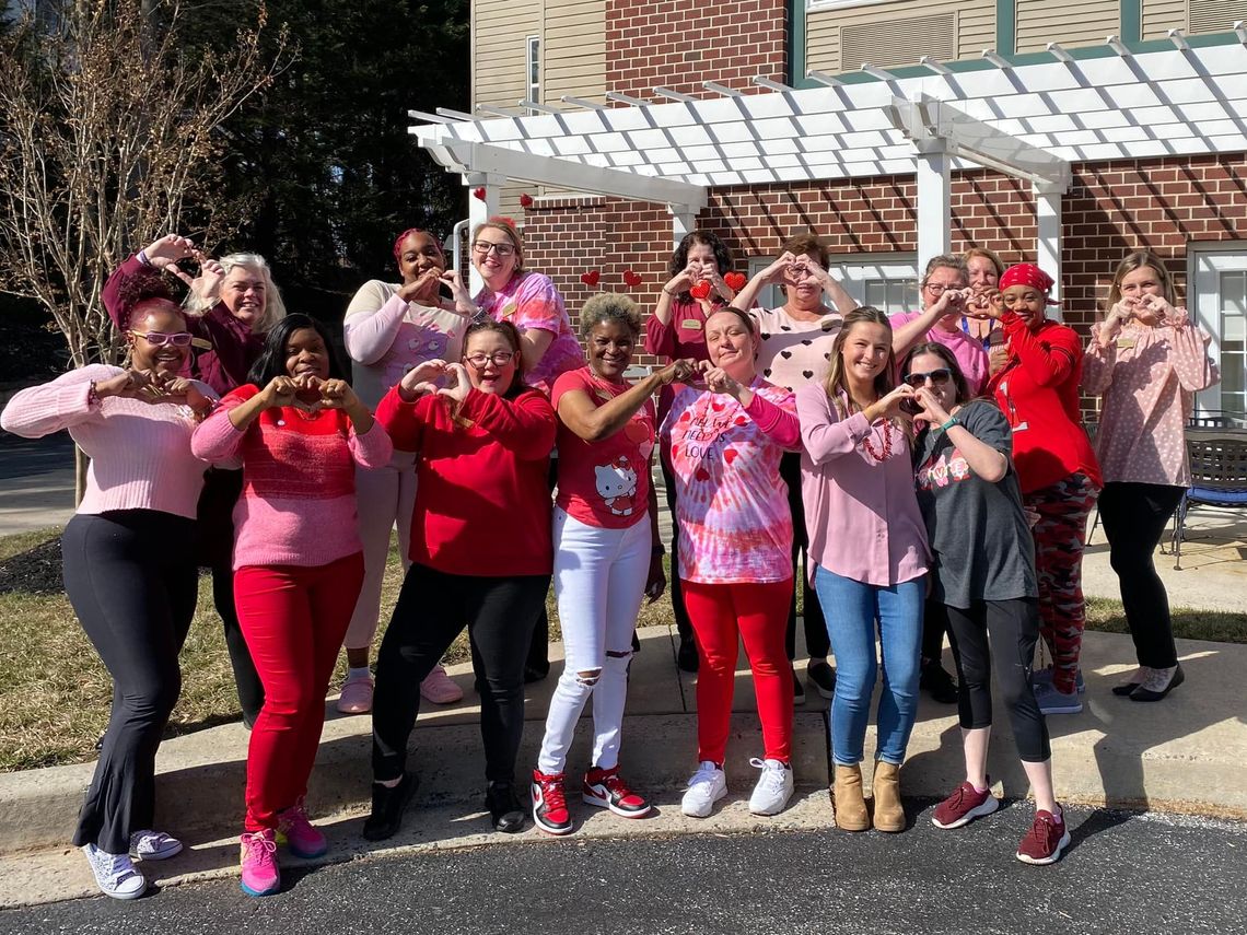 Staff members posing in red clothing for a group photo