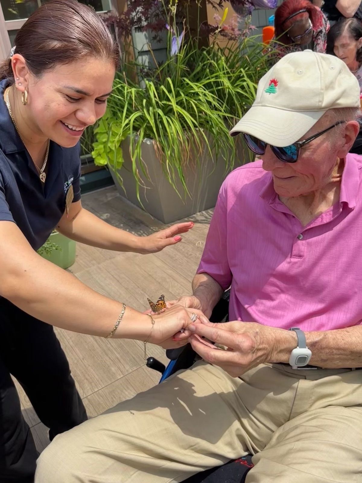 Resident and staff member sharing a butterfly moment outdoors