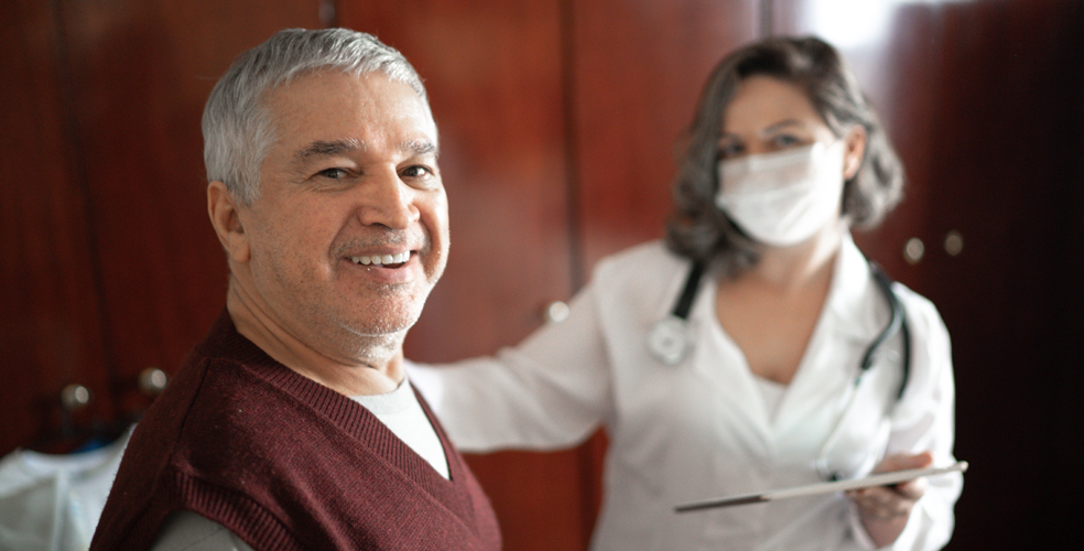 A smiling resident with staff member in a cozy setting