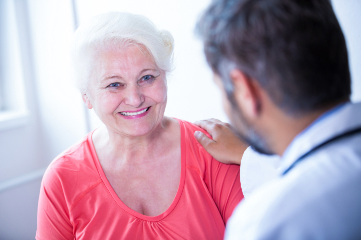 A smiling elderly woman with a caregiver
