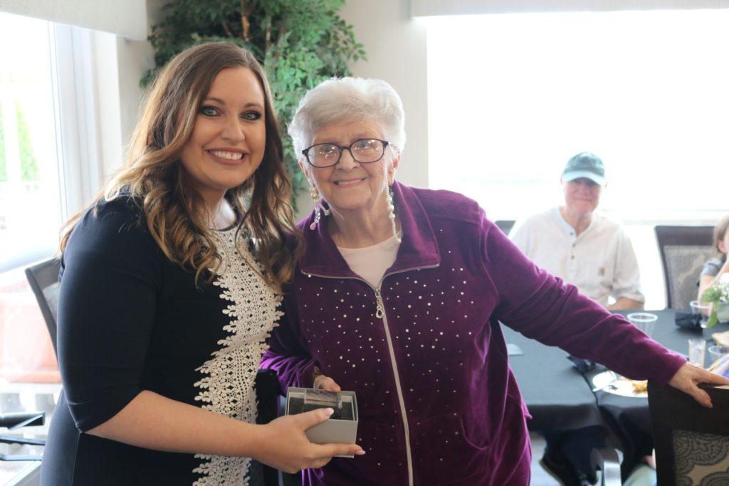 Resident and staff member smiling together at a gathering