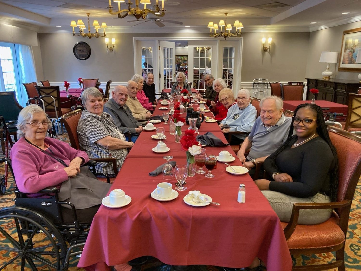 Residents and staff enjoying a meal together in the dining room