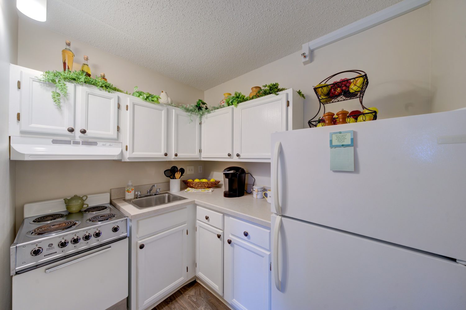 Bright kitchen area with white cabinets and appliances