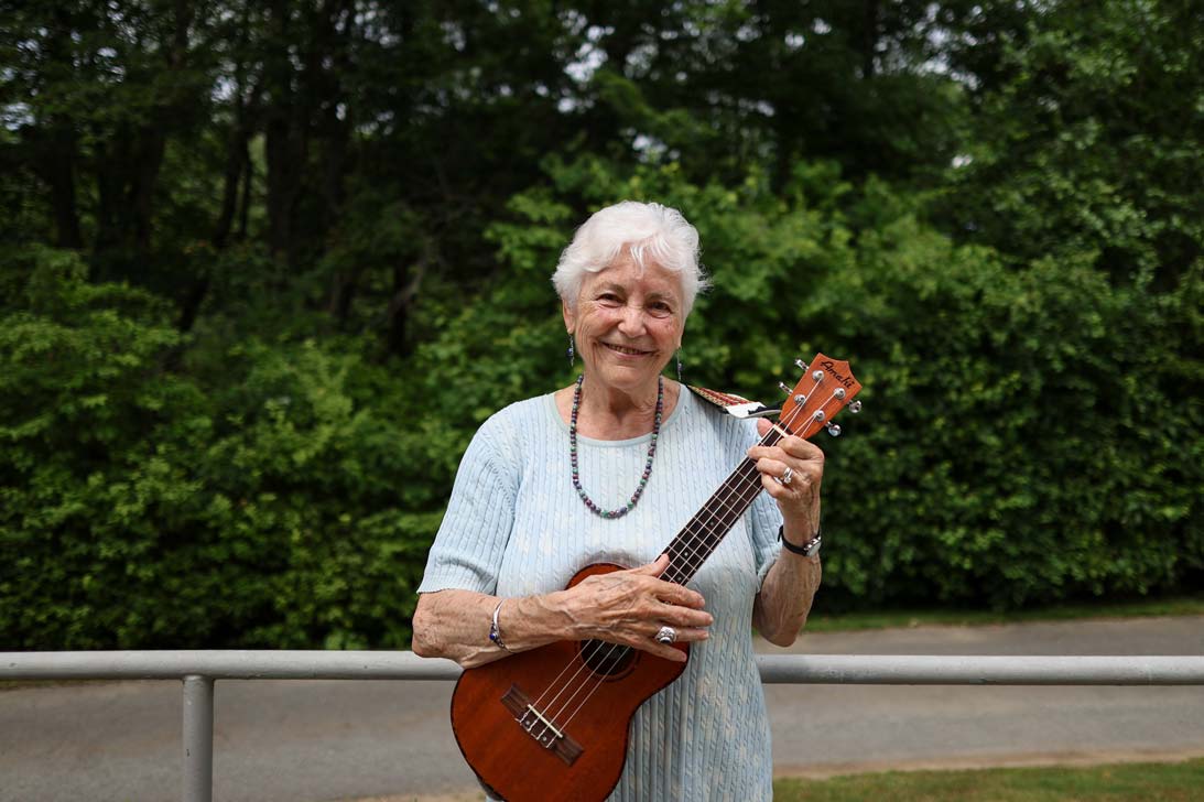 Resident playing ukulele outdoors