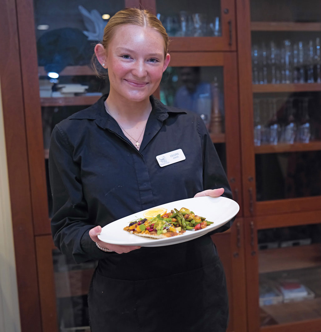 Staff member presenting a delicious plate of food