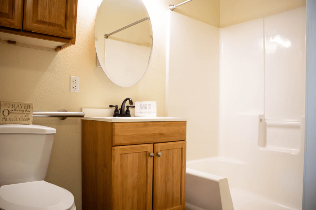Clean bathroom with wooden cabinets and mirror