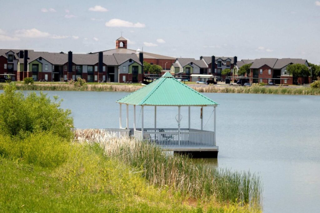 Gazebo by the lake with residential buildings in the background