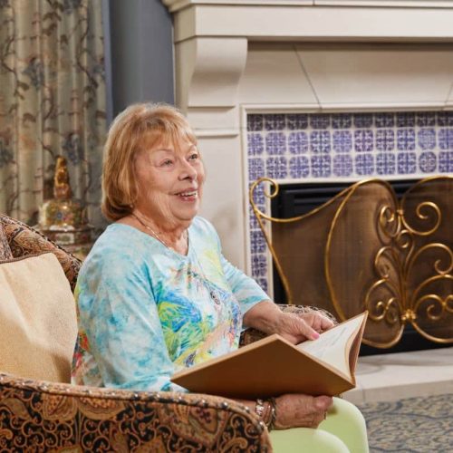 Senior resident reading in a cozy lounge