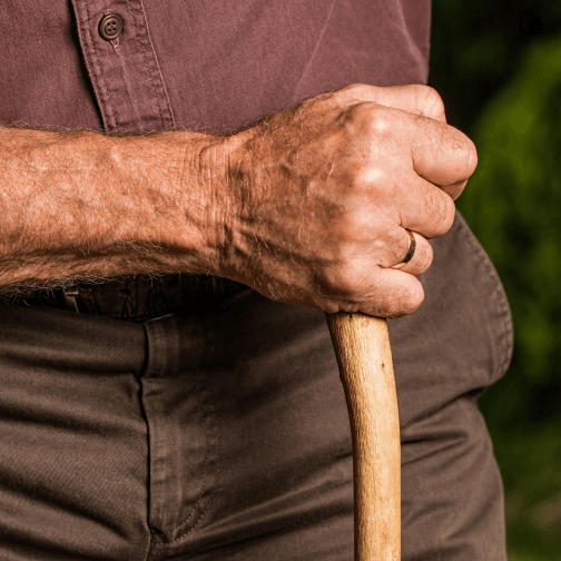 A close-up of a hand holding a cane.