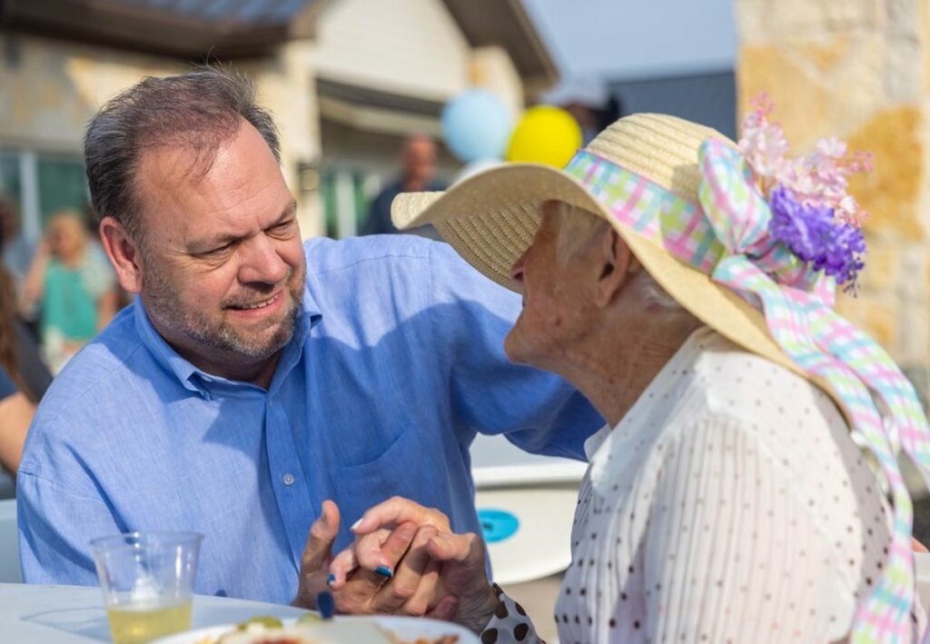 Smiling interactions between a man and an elderly woman outdoors