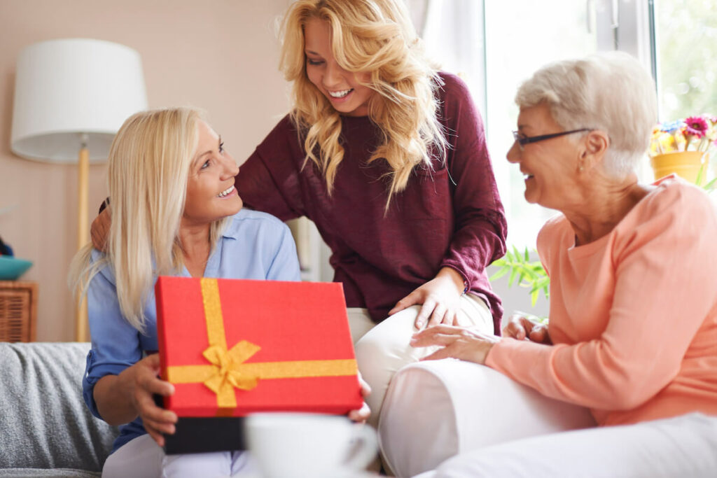 Residents celebrate with gifts and smiles in a cozy setting.