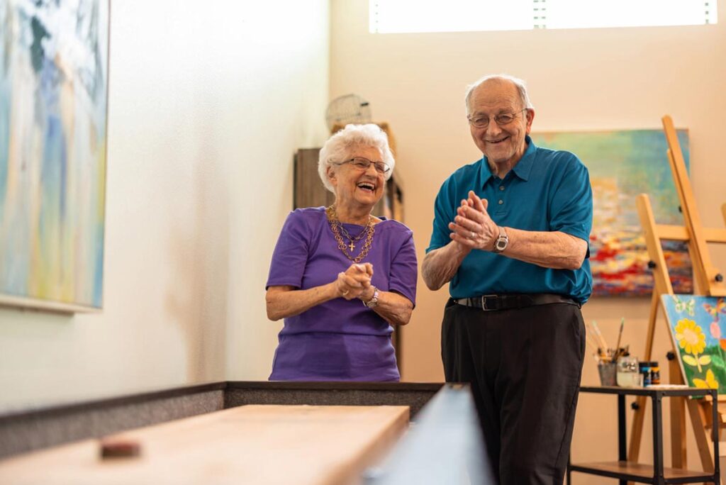 Two seniors engaged in an art activity.