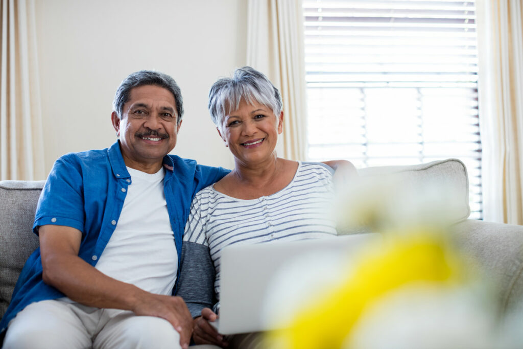 Happy senior couple sitting together with a laptop