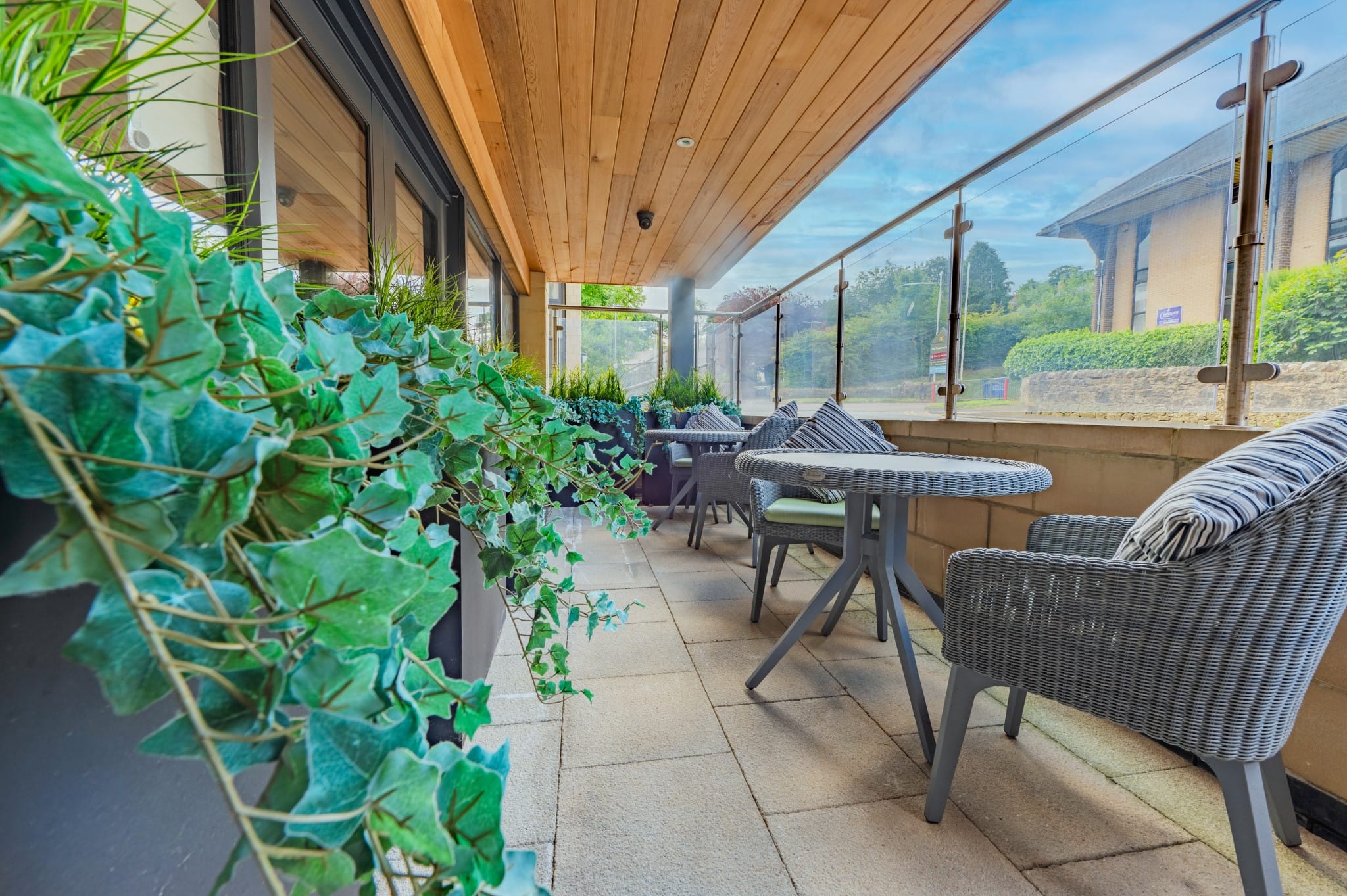 Outdoor seating area with greenery and tables.