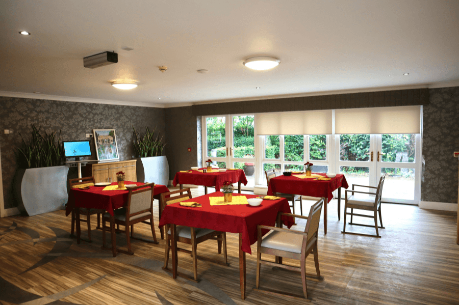 Dining room with red tablecloths and large windows