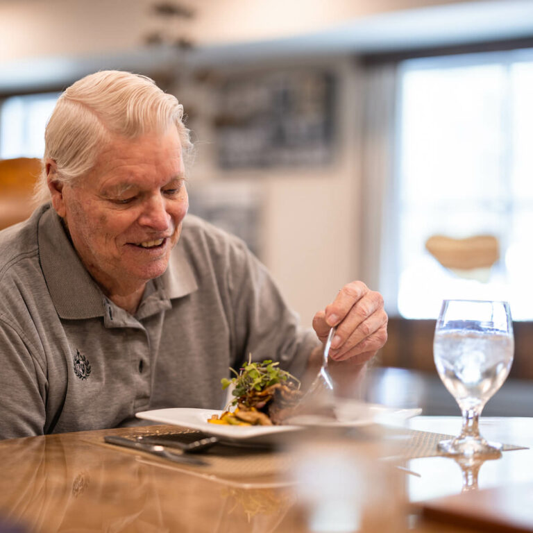 Resident enjoying a meal in the dining area.