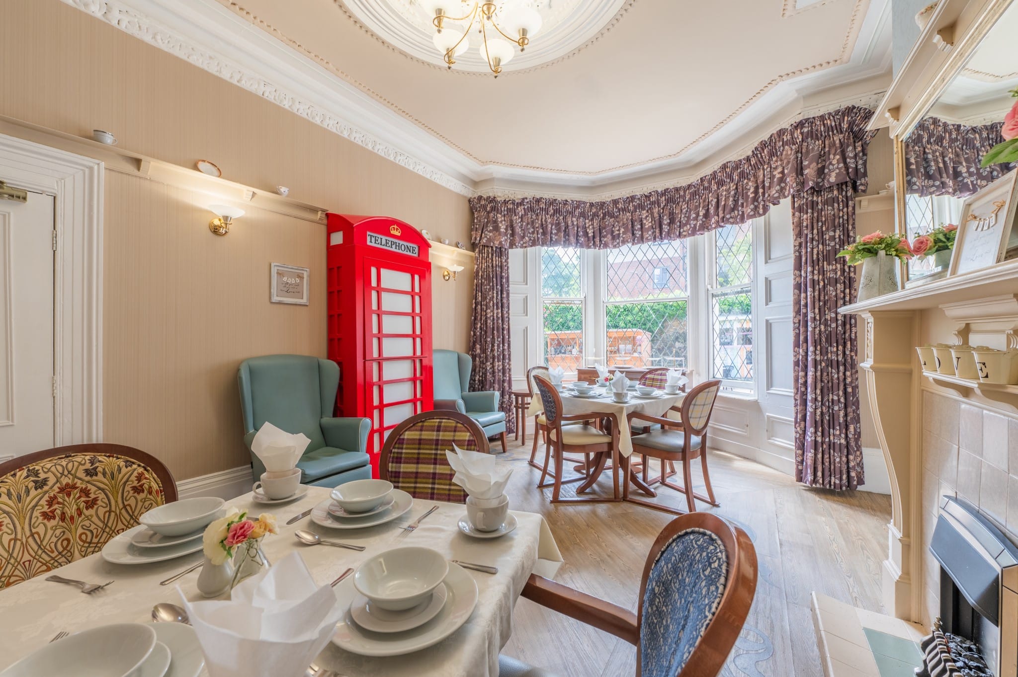 Dining area with elegant table setting and vintage telephone booth.
