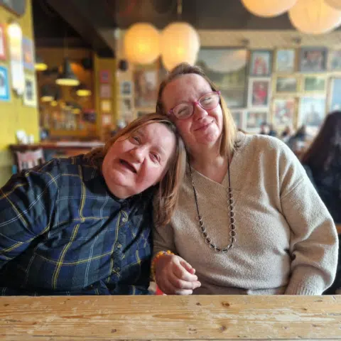 Two women smiling together in a cozy interior