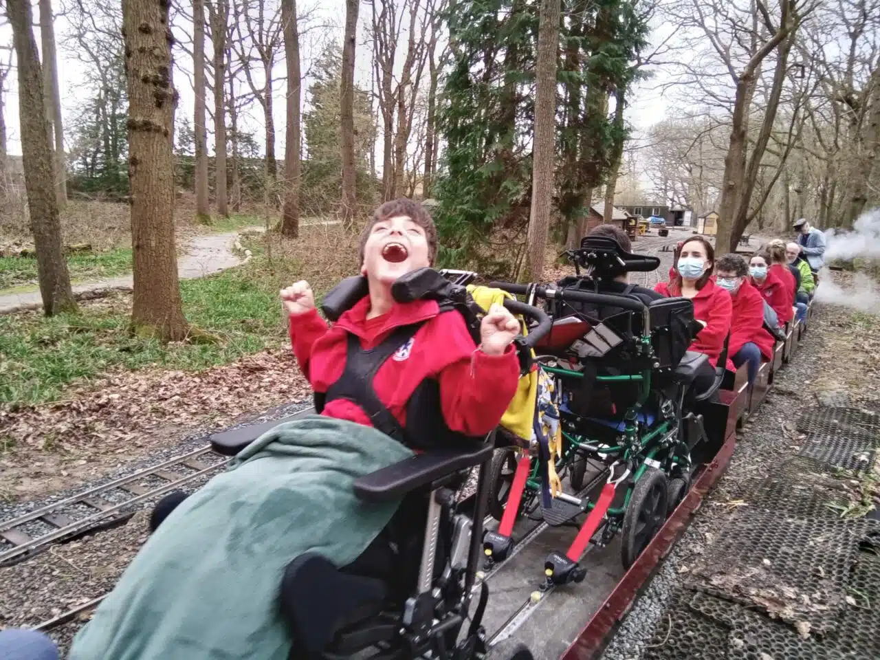Residents enjoying a ride on a train in the park.