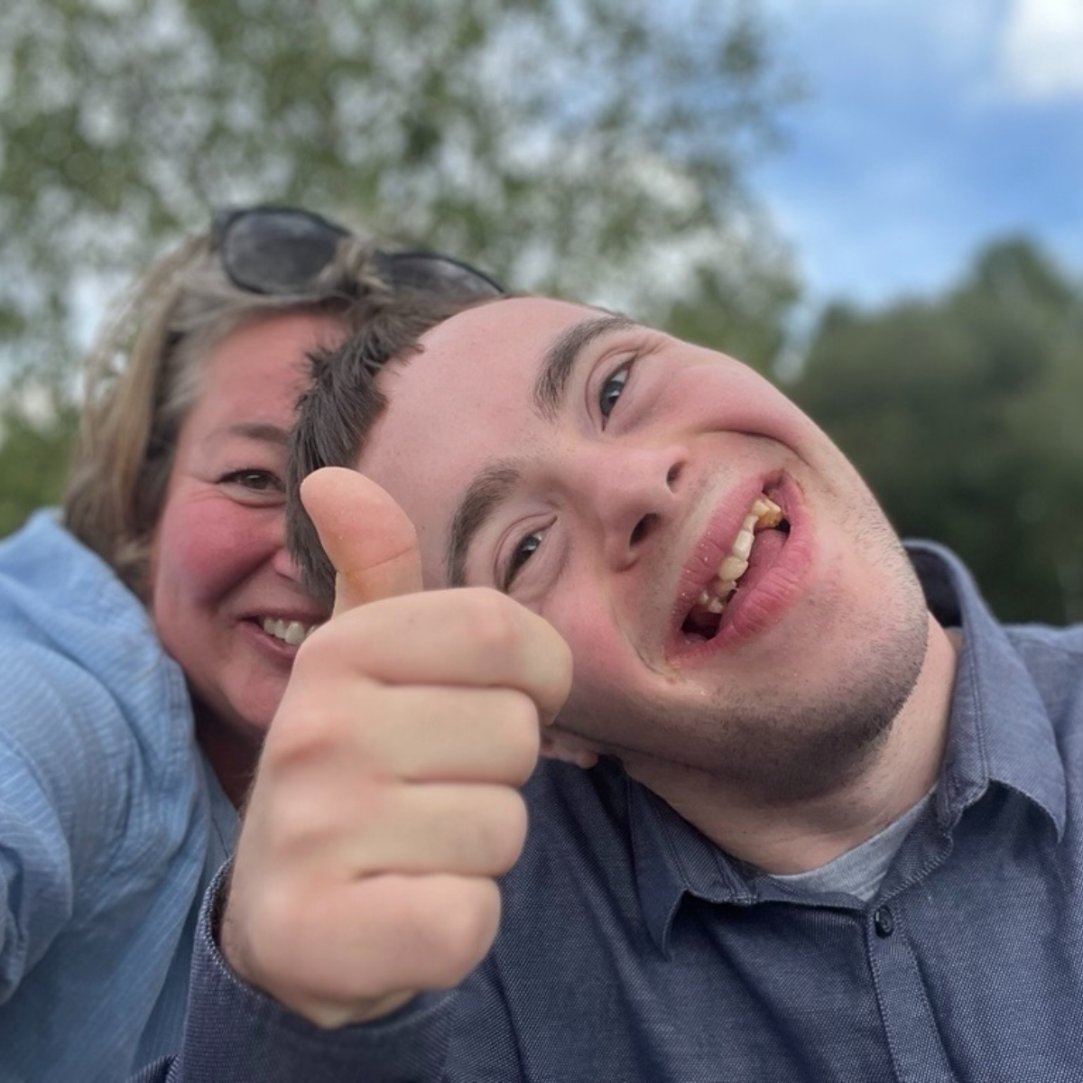 Two people enjoying the outdoors with a thumbs up.
