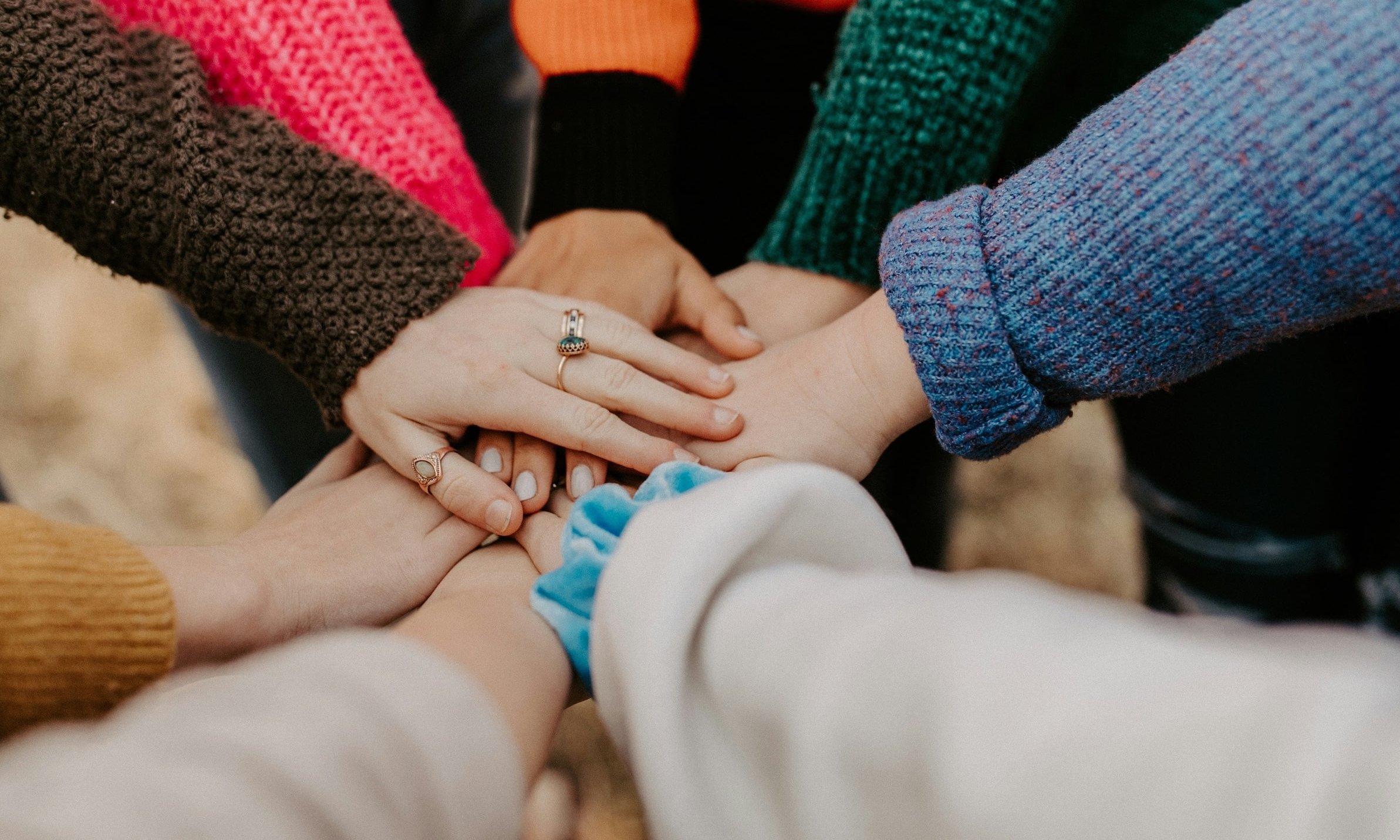 Diverse hands coming together in a circle.