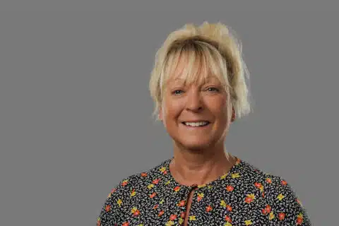 Smiling woman wearing a floral patterned shirt
