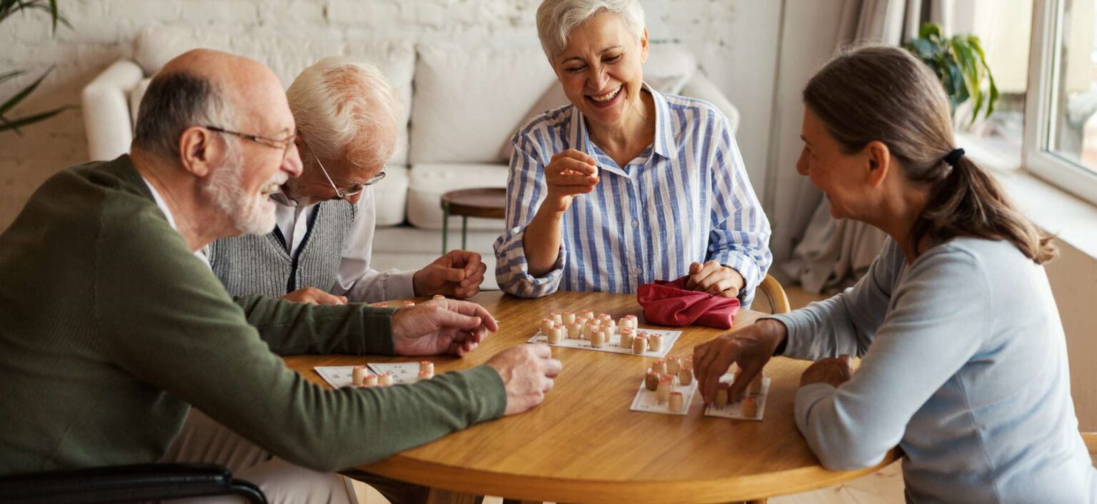 Residents engaging in a game at a communal table.