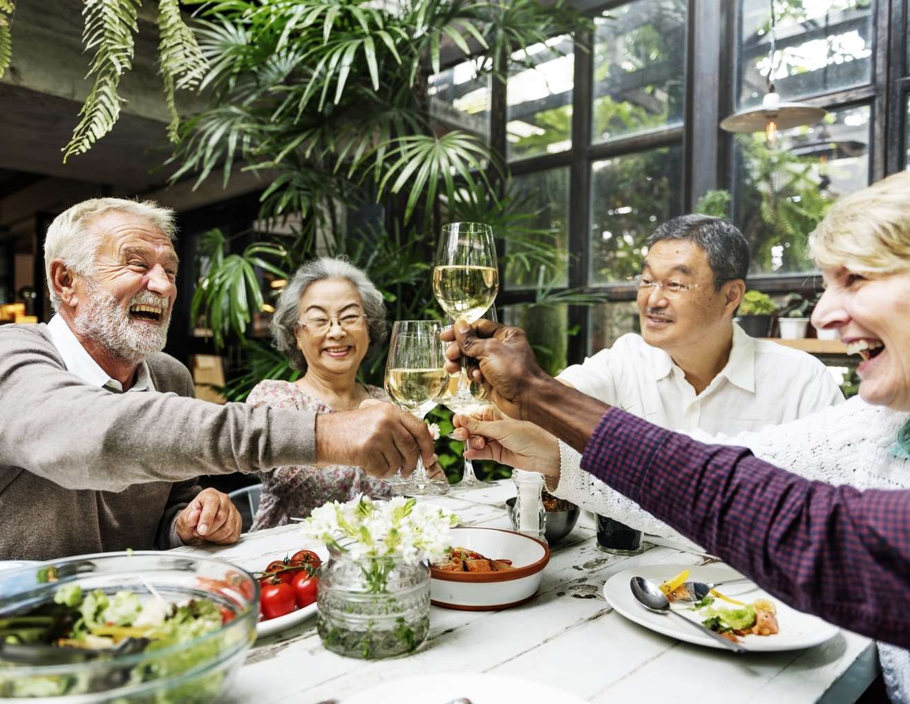 Seniors toasting with glasses at a table