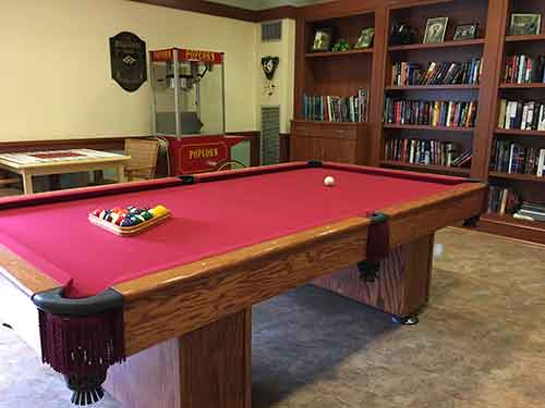 Pool table in a common area with bookshelves