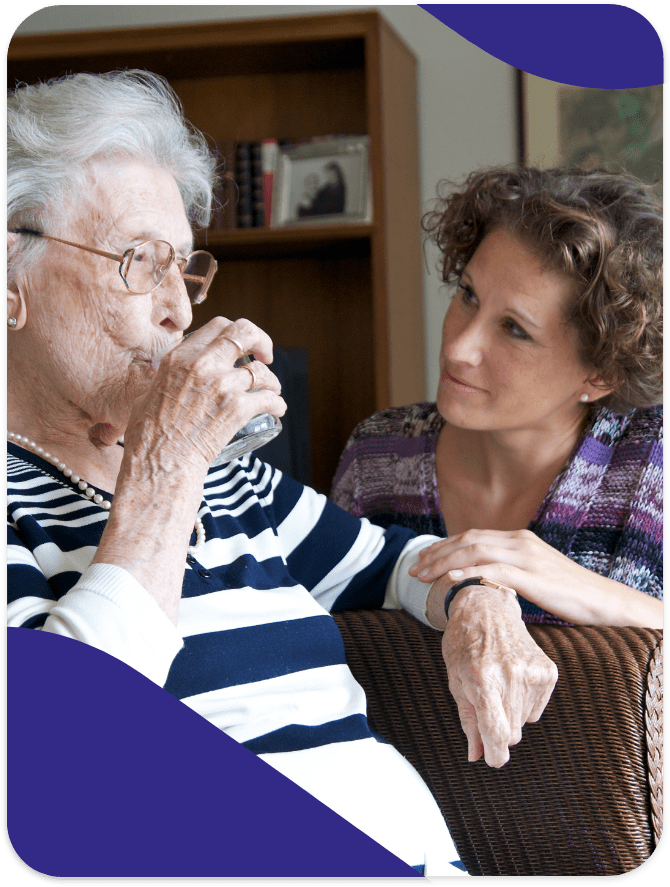 Senior woman enjoying a drink with caregiver