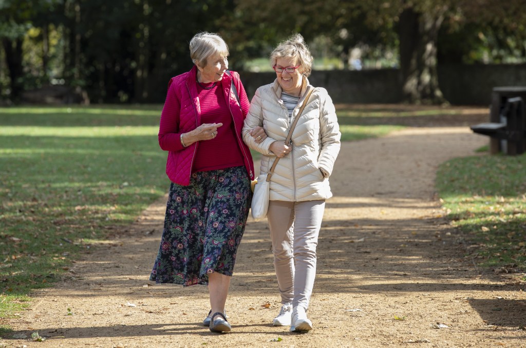 Two women walking together in a park