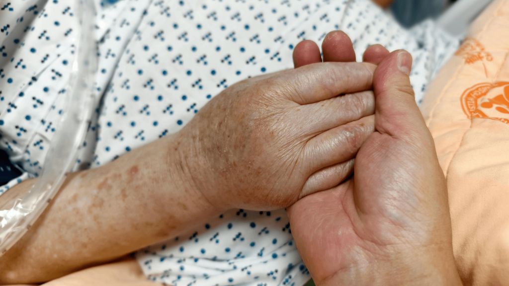 Two hands gently holding each other