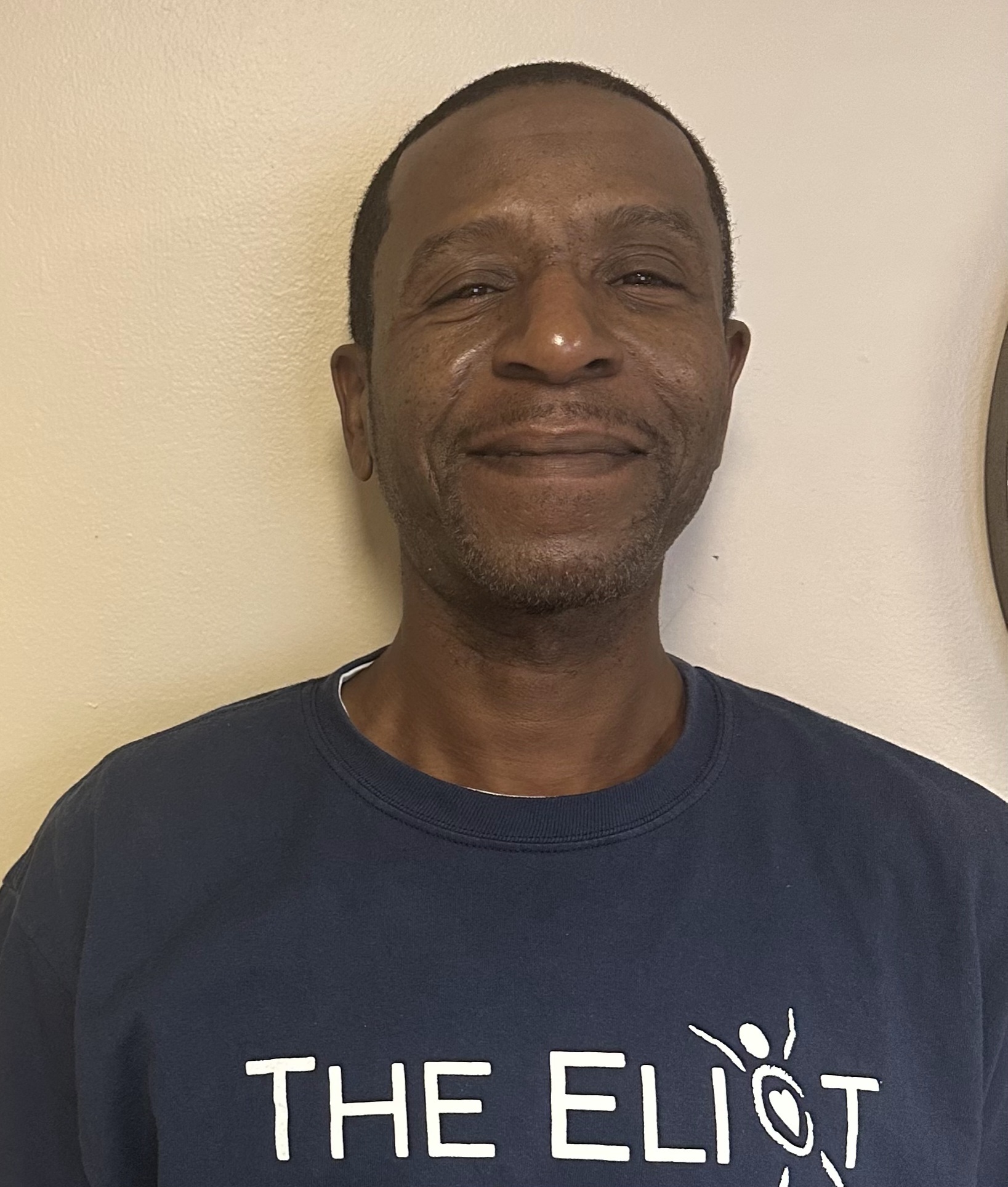 Resident wearing a facility t-shirt, smiling.