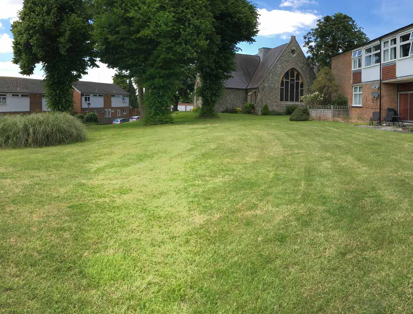 Outdoor space with grass and a building in background.