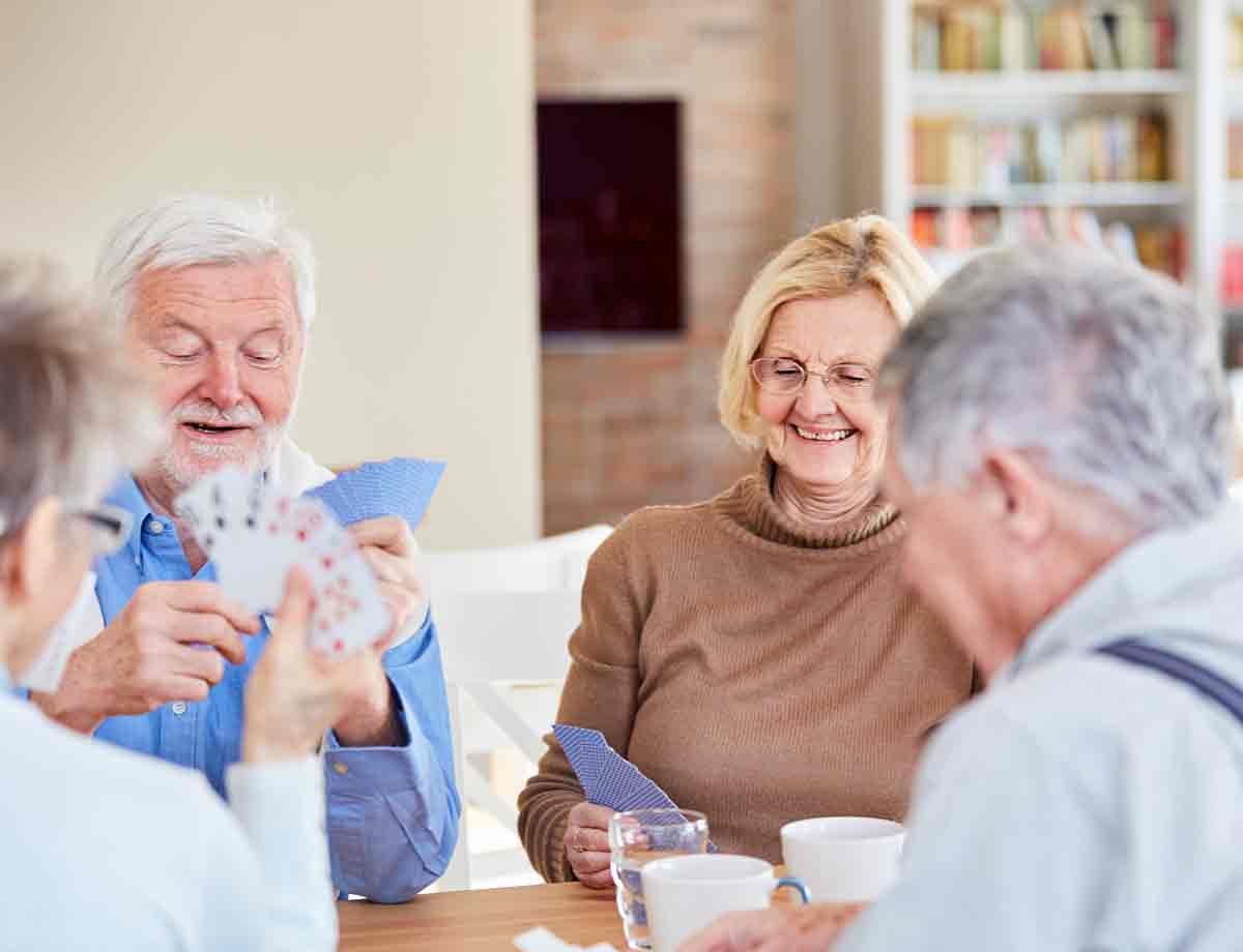 Seniors playing cards in a common area