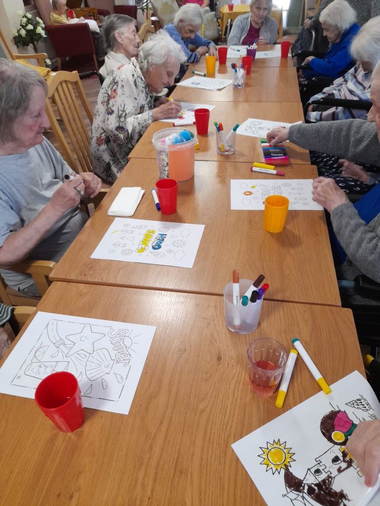 Residents engaging in coloring activity at a table