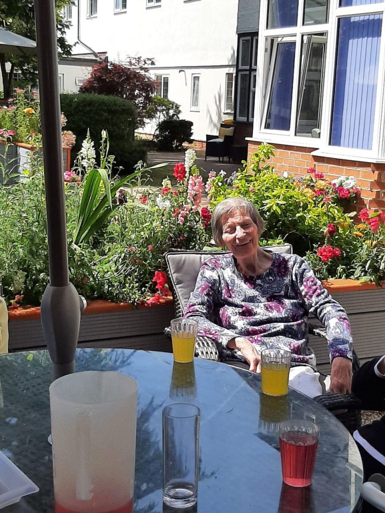 Resident enjoying drinks in a garden setting