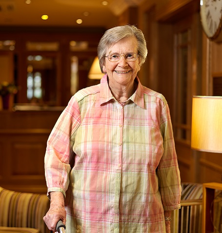 Resident smiling in a comfortable common area.