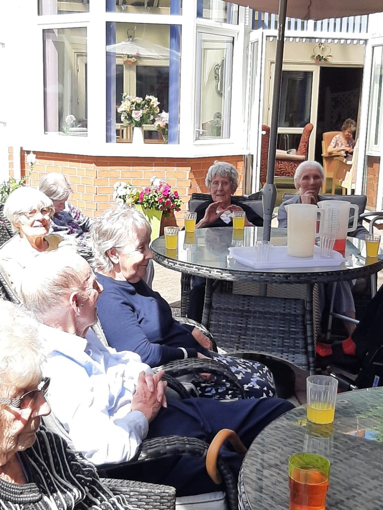 Residents enjoying a sunny day outdoors at the facility