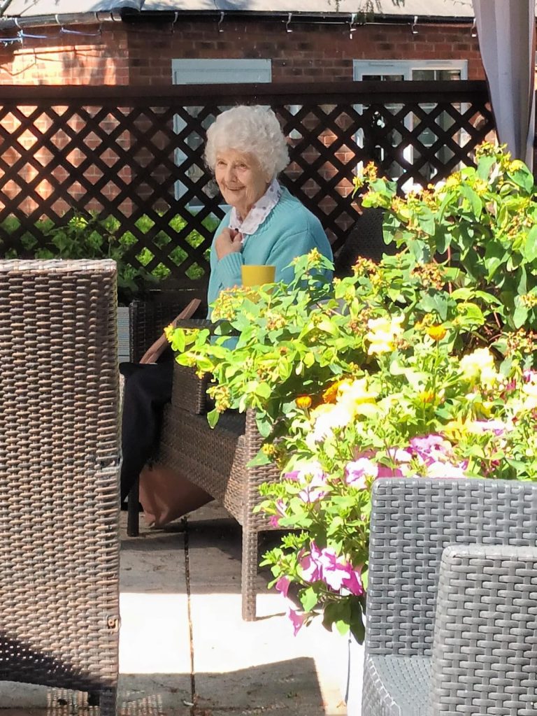 Senior woman enjoying a garden patio