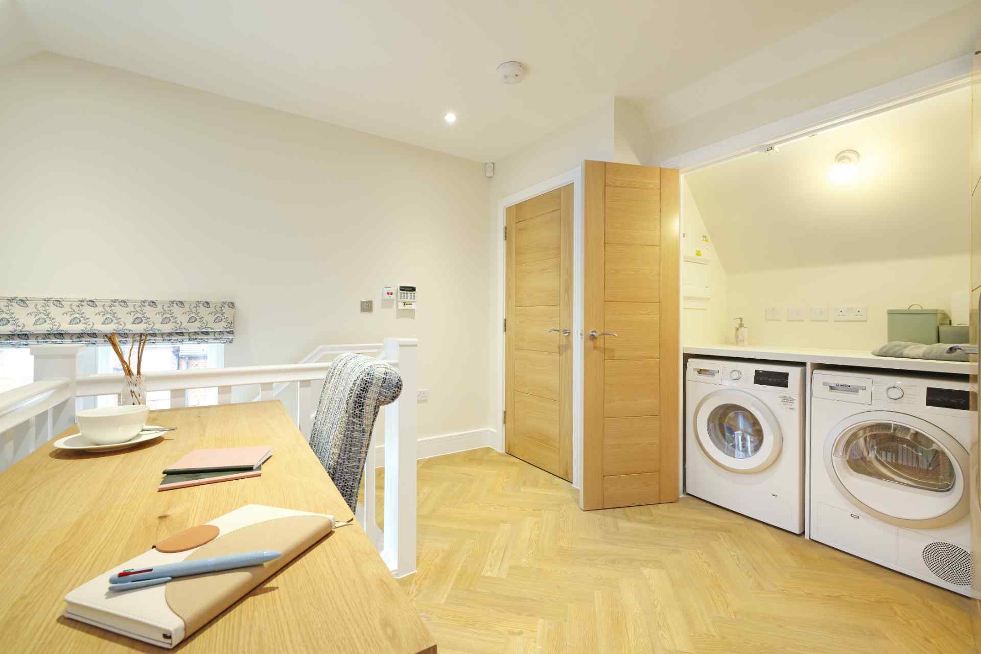 Bright laundry area with wooden table and appliances.