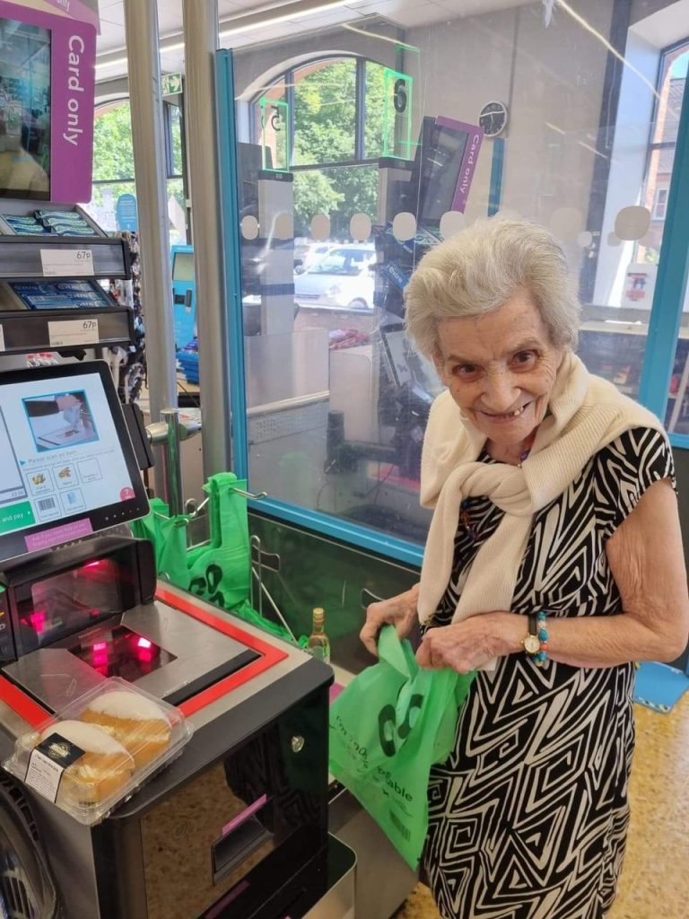 Senior woman using a self-checkout at a store