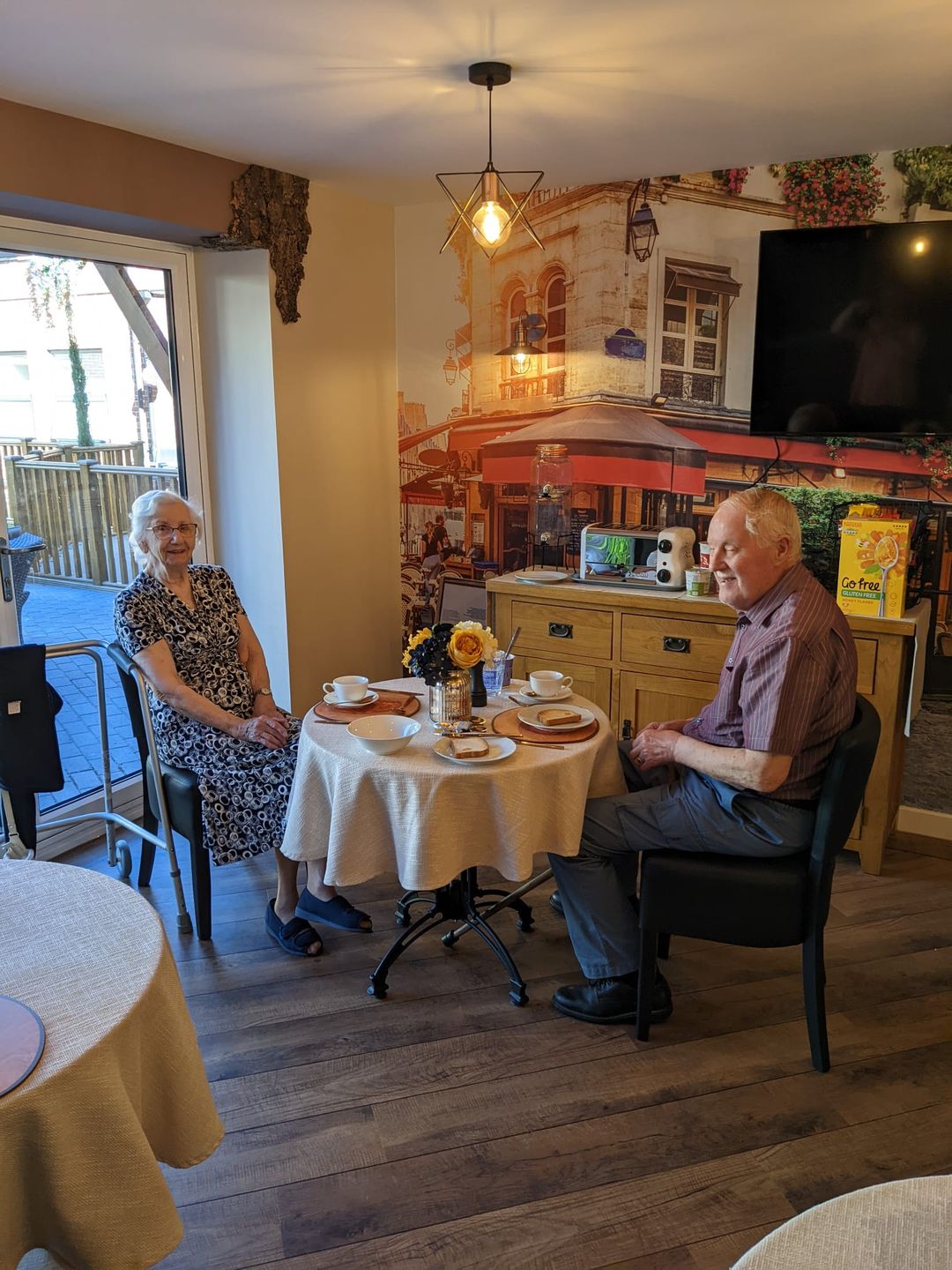 Two residents enjoying tea and pastries together.