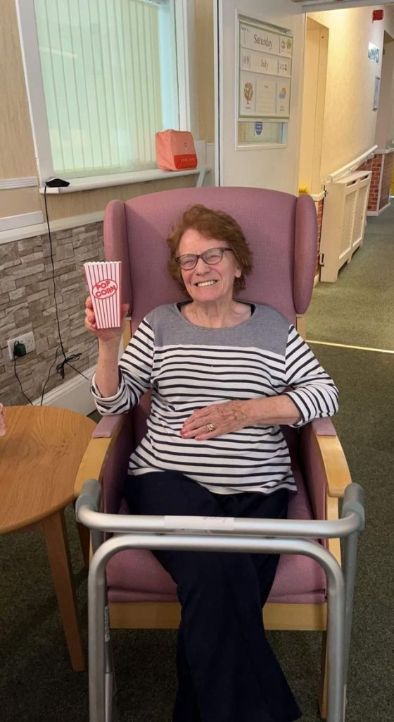 Resident enjoying a snack in a chair