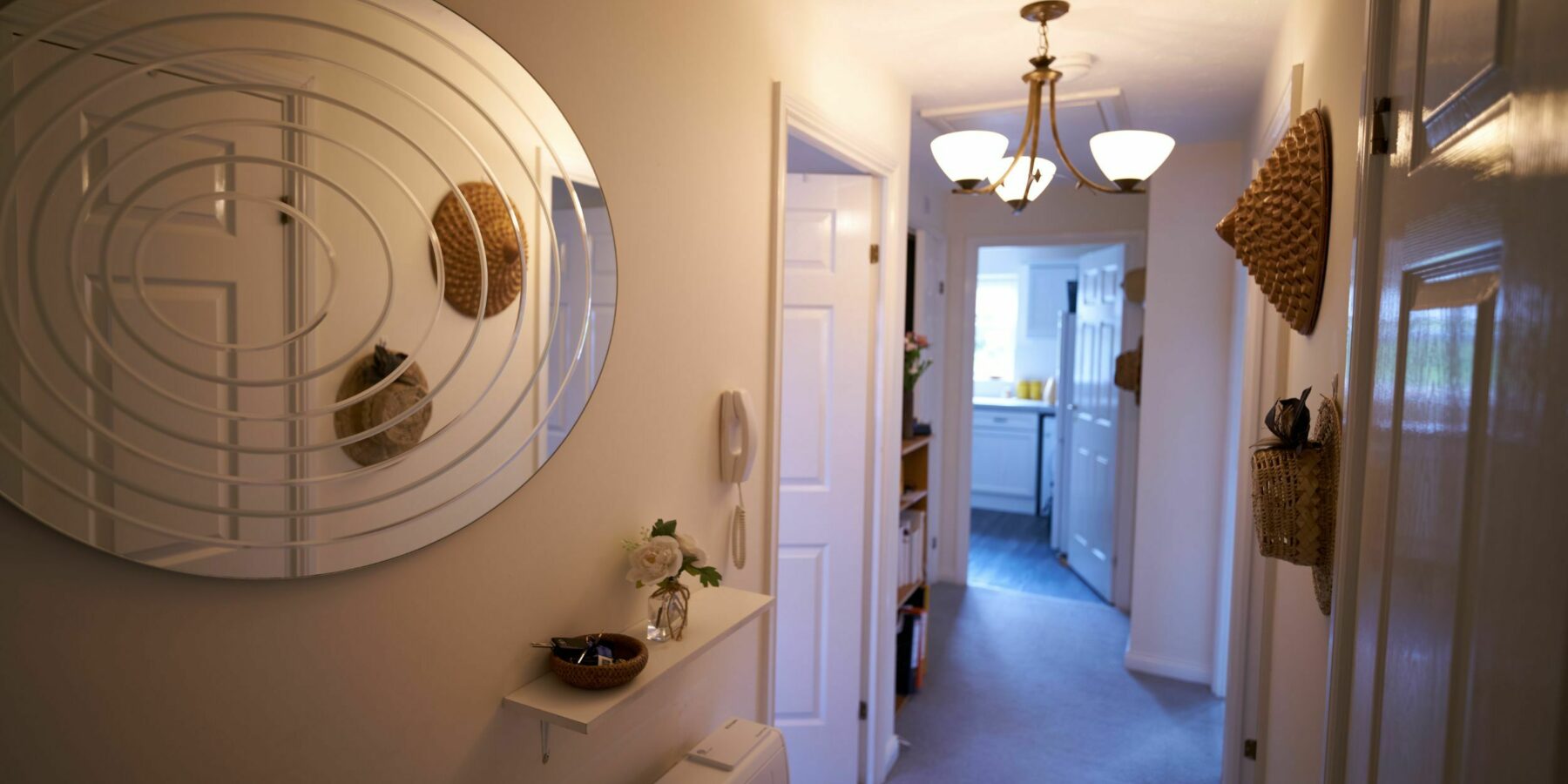 A well-lit interior hallway with a circular mirror.