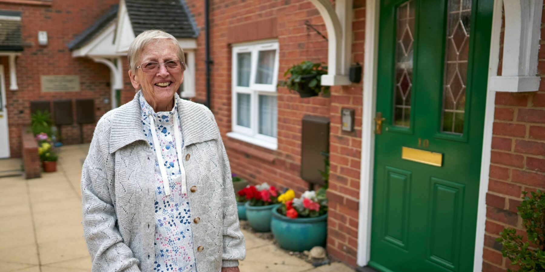 Smiling resident standing by the entrance
