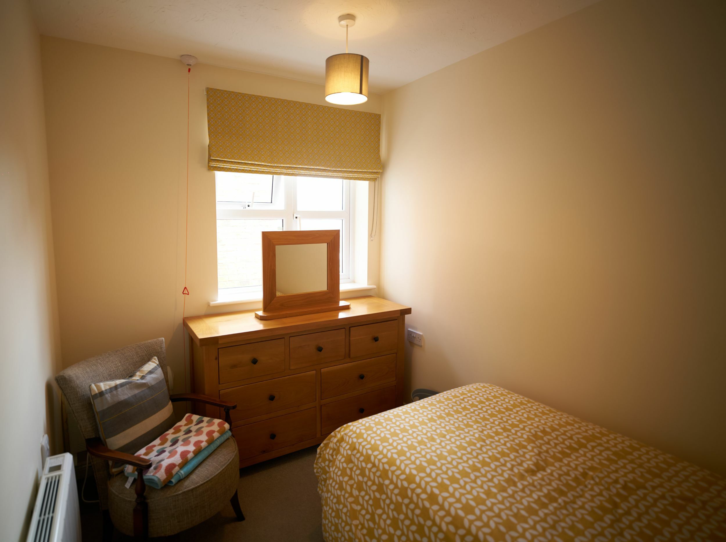 Cozy resident room with a bed and dresser.
